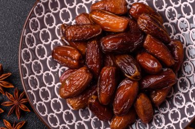 Ramazan ya da iftar için seramik bir tabakta kurutulmuş tarihler. Tasarımınız için kuru tarihler gıda arka planı olarak kullanılacaktır