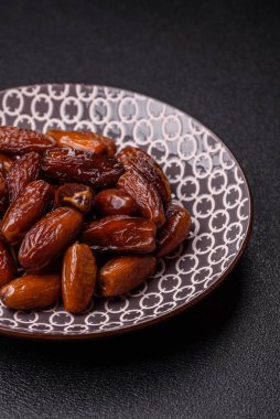 Ramazan ya da iftar için seramik bir tabakta kurutulmuş tarihler. Tasarımınız için kuru tarihler gıda arka planı olarak kullanılacaktır