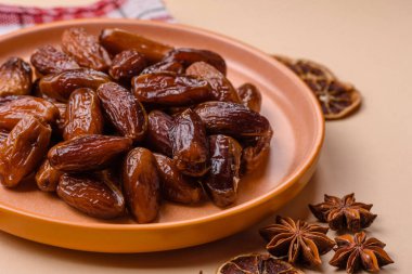 Ramazan ya da iftar için seramik bir tabakta kurutulmuş tarihler. Tasarımınız için kuru tarihler gıda arka planı olarak kullanılacaktır