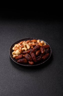 Ramazan ya da iftar için seramik bir tabakta kurutulmuş tarihler. Tasarımınız için kuru tarihler gıda arka planı olarak kullanılacaktır