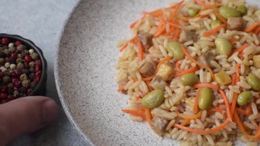 Pirinç, edamame, havuç, tofu ve baharatlı Asya yemekleri. Edamame ve havuçlu pilav tasarımınız için gıda arka planında.