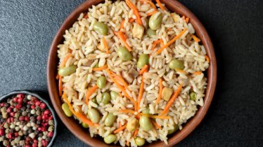 Pirinç, edamame, havuç, tofu ve baharatlı Asya yemekleri. Edamame ve havuçlu pilav tasarımınız için gıda arka planında.