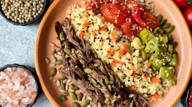 Biftek, yulaf lapası, mantar, sebze, sos ve baharatlı bir kase. Tasarımınız için yemek arka planı olarak biftek kasesi