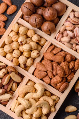 Sağlıklı gıda malzemesi olarak kaju, fıstık, badem, Brezilya fındığı, macadamia ve fındık karışımı. Tasarımınız için yemek arkaplanı olarak fındık