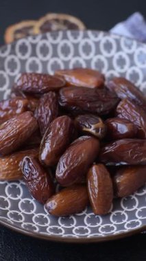 Ramazan ya da iftar için seramik bir tabakta kurutulmuş tarihler. Tasarımınız için kuru tarihler gıda arka planı olarak kullanılacaktır