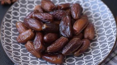 Ramazan ya da iftar için seramik bir tabakta kurutulmuş tarihler. Tasarımınız için kuru tarihler gıda arka planı olarak kullanılacaktır