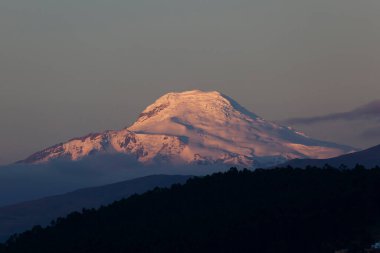 Volcan Cayambe al atardecer 'ı ziyaret ediyor