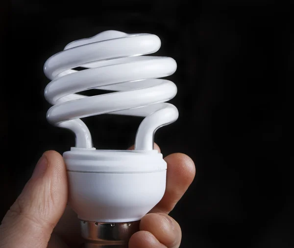 Hand som håller låg energi glödlampa — Stockfoto