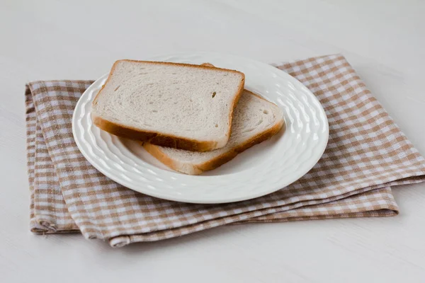 Kawałek Chleba Talerzu Białym Drewnianym Stole Beżowy Ręcznik Kuchenny Przygotowanie — Zdjęcie stockowe