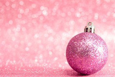 Pembe parlak Noel ağacı oyuncağı pembe kristal arka planda Bokeh ile. Noel kartı. Uzayı kopyala Yumuşak odak