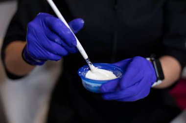 Kozmetik uzmanının ellerinin maske soyma malzemelerini karıştırırken çekilmiş yakın plan fotoğrafı.