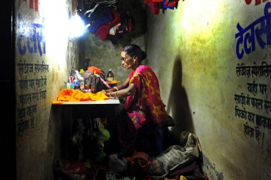 Bombay, Hindistan 8.2019 kadın işi, dikiş makinesi olan bir kadın mahzende çalışıyor, terzilik ve el işi.