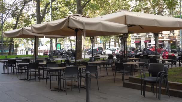Italy , Milan October 2020 - Corso Sempione - Empty tables, closed pubs, restaurants, bars and venues due to coronavirus, covid-19 outbreak. All businesses with public are temporary closed — Stock Footage Italy Milan October 2020 Corso Sempione Empty Tables Closed Pubs Royalty Free Stock Video