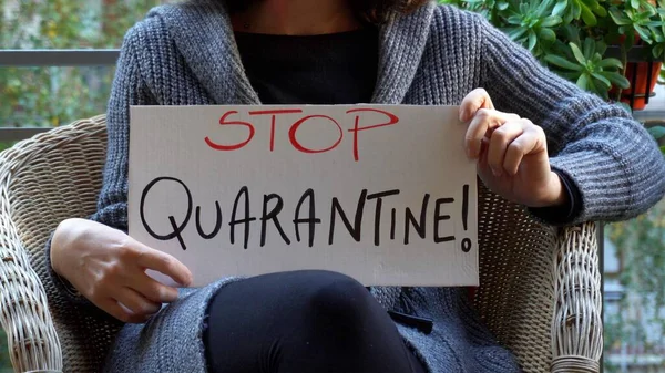 woman holding board in hands, stop quarantine text