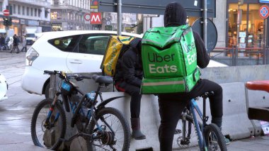 İtalya, Milano - 25 Eylül 2019: bisikletçiler eve, ofise ya da ihtiyacınız olduğunda yiyecek getiriyor. Uber en önemli yiyecek dağıtımını yapar.