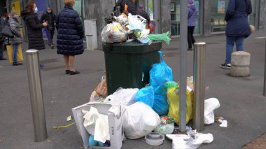 Avrupa, İtalya, Milano Aralık 2020 - çöpler sokaklarda birikmiş ve Covid-19 Coronavirus sırasında Giambellino ilçesinde çöp torbaları arasında yürümekte zorlanan yaşlılar
