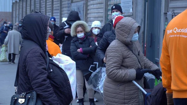 ヨーロッパ イタリア ミラノ2020年12月 貧しいイタリア人とマスクを持つ外国人は Covid 19コロナウイルス 失業者の増加 経済危機の間に無料の食べ物のためにパンQuotidianoに並んでいます — ストック写真