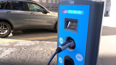 İtalya - Milano 26 Aralık 2020 - Milano şehir merkezi manzarası. Otomobilin geleceği olan 22şarjlı modern elektrikli araba.
