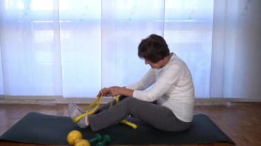 Yaşlı bayan Covid19 Coronavirus karantina evindeyken evde jimnastik ve yoga meditasyonu yapıyor. Salgın sırasında yaşam biçimi