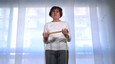 Yaşlı bayan Covid19 Coronavirus karantina evindeyken evde jimnastik ve yoga meditasyonu yapıyor. Salgın sırasında yaşam biçimi