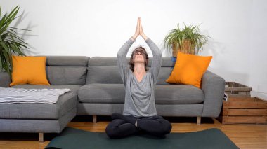 30 yaşındaki bayan Covid-19 Coronavirus karantina evinde yoga meditasyonu yapıyor - oturma odasında yaşam tarzı