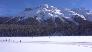 Avrupa, İsviçre, Saint Moritz Şubat 2021 - Sanit Moritz 'de donmuş göl manzarası Covid-19 Coronavirus salgını sırasında insanların karda yürümesi