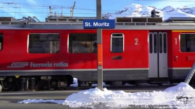 İsviçre Alpleri, Saint Moritz Şubat 2021 - Bernina Ekspresi, Saint Moritz istasyonundaki Bernina treni - Unesco dünya mirası - Rhaetian demiryolu güneşli bir günde mavi gökyüzü, tren tren görüntüleri 
