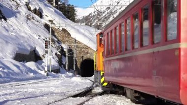 İsviçre Alpleri, Saint Moritz Şubat 2021 - Bernina Ekspresi, Saint Moritz istasyonundaki Bernina treni - Unesco dünya mirası - Rhaetian demiryolu güneşli bir günde mavi gökyüzü, tren tren görüntüleri 