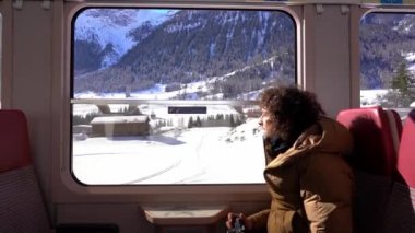Gezgin blogcu Kafkasyalı 40 yaşında dağ manzarası gezisi sırasında tren penceresinden fotoğraf ve video çekiyor. Bernina Express, Unesco miras dünyası. 