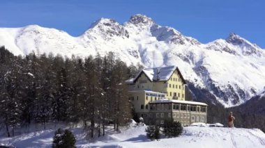 İsviçre Alpleri, Poschiavo Şubat 2021 - Bernina Express 'in insansız hava aracı görüntüsü, Bernina' nın Ospizio Bernina istasyonundaki kırmızı treni - Unesco dünya mirası - Lago Bianco (beyaz göl) 