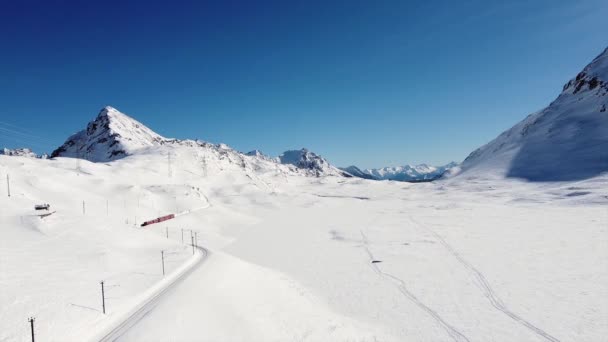 瑞士和意大利 从地拉诺到圣莫里茨的Bernina Red Express和Chur 教科文组织世界遗产所在地 无人驾驶飞机俯瞰 有冰冻白湖的Ospizio Bernina站 — 图库视频影像