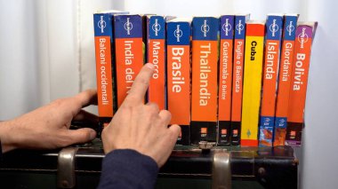 EUROPE, İtalya, MILAN Mart 2021 - Bir kütüphane evinde turizm koleksiyonu için Yalnız Gezegen Seyahat Rehberi - Covid-19 Coronavirus karantina evinden sonra seyahat etmek istiyor