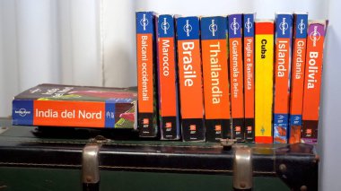 EUROPE, İtalya, MILAN Mart 2021 - Bir kütüphane evinde turizm koleksiyonu için Yalnız Gezegen Seyahat Rehberi - Covid-19 Coronavirus karantina evinden sonra seyahat etmek istiyor