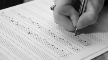 Müzisyen kız eli notaları notalarla birlikte beste yapıyor - üç tuşlu nota ve klasik melodi yazıları