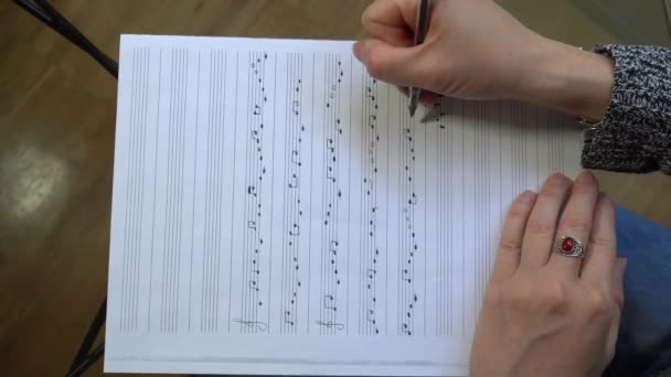 音楽家の作曲家の女の子の手は楽譜シートに音符で音楽を書きます 高音の音の音と古典的なメロディーの曲の書き込み — ストック動画