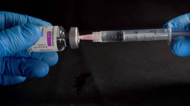 Avrupa, İtalya Milano - Covid-19 Coronavirus 'a karşı Nisan 2021 Aşı - AstraZeneca Aşısı - hastanede doktor eli ve babası - siyah arka plan 