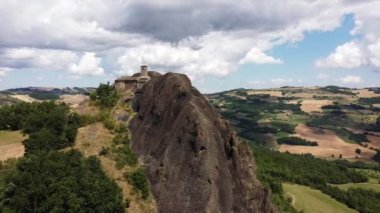 Avrupa, İtalya, Travo, İHA hava manzaralı Pietra Perduca Val Trebbia Bobbio 'da ekili arazisi olan taşa batırılmış tipik bir kilise ile inanılmaz bir volkanik kayadır.