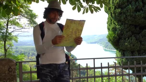 40歳の孤独な旅行者は 目的地を決めるために道路地図を見て旅行を計画 Covid 19コロナウイルスの間に旅行 — ストック動画