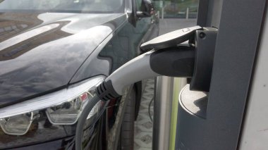 Avrupa, İtalya, Milano - Otomobilin geleceği olan caddelerde modern elektrikli araba şarj etmek - halka açık bir otoparktaki arabalar için elektrik şarj istasyonu