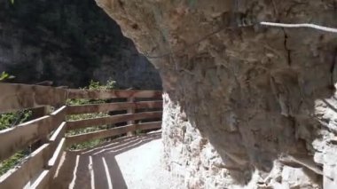 Avrupa, İtalya, Trentino Alto Adige Ağustos 2021 - San Romedio (San Romedius) inziva mabedini ziyaret eden turistler dağa oyulmuş kayadan geçen patikadan geçtiler