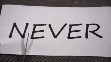 Asla okumak için kelime kesme. Motivasyon ve teşvik amacını ifade etmek için makası kullanan bir kadın eli. Pozitif düşünme kavramı, kendine güven ve başarının başarısı.