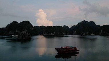 Sakin su bulutları ve dağları yansıtıyor.