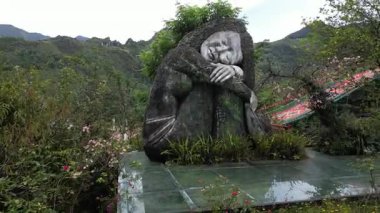 Yeşil dağlı heykel ve köprü manzarası