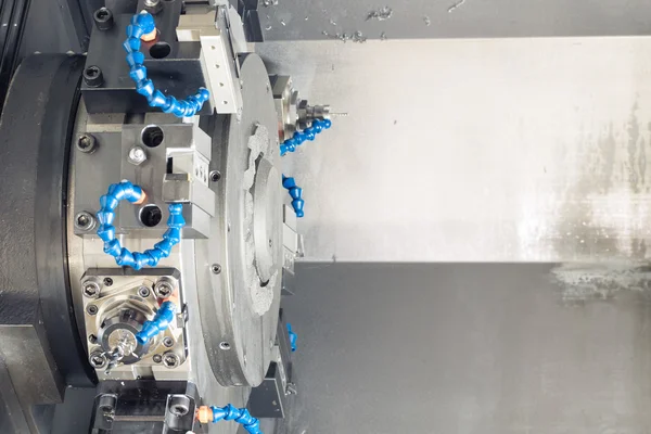 Metall-Rohling-Bearbeitungsprozess auf Drehmaschine mit Schneidwerkzeug und Kühlmittel bei der Stahlproduktion — Stockfoto