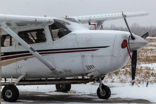 small aircraft with a propeller at the airfield, airport in the snow in winter