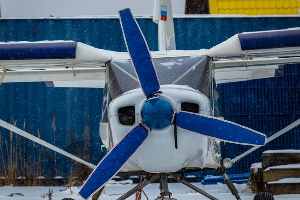 small aircraft with a propeller at the airfield, airport in the snow in winter