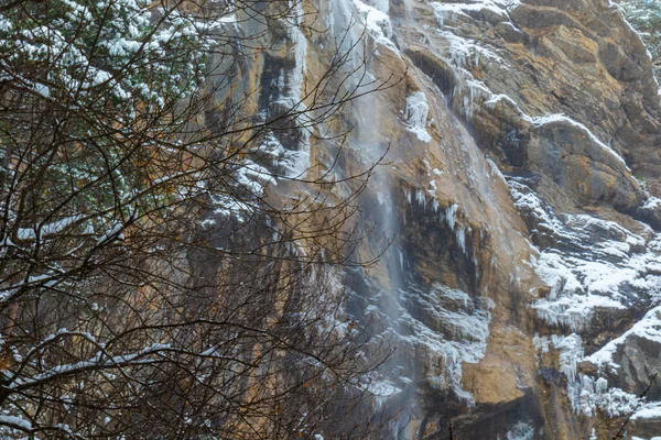 Dağlarda güzel kış manzaraları, ağaçlar, bitkiler, kayalar, şelaleler, sarkıtlar, soğuk havada düşen kar.