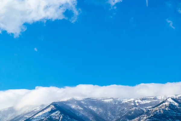 beautiful, big mountains with snow in the clouds against the blue sky with clouds on vacation, travel