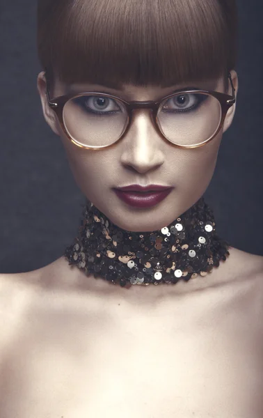 Retrato de una joven con gafas y collar —  Fotos de Stock