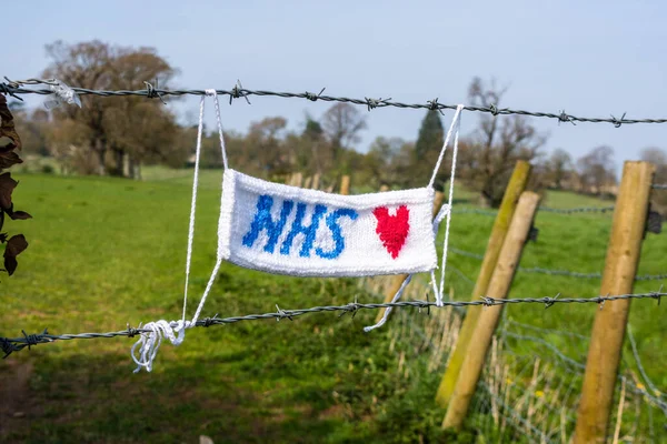 NHS ile örülmüş bir dikdörtgen ve dikenli tellere bağlanmış bir aşk kalbi korona virüsünün kilitlenmesi sırasında destek gösteriyor.